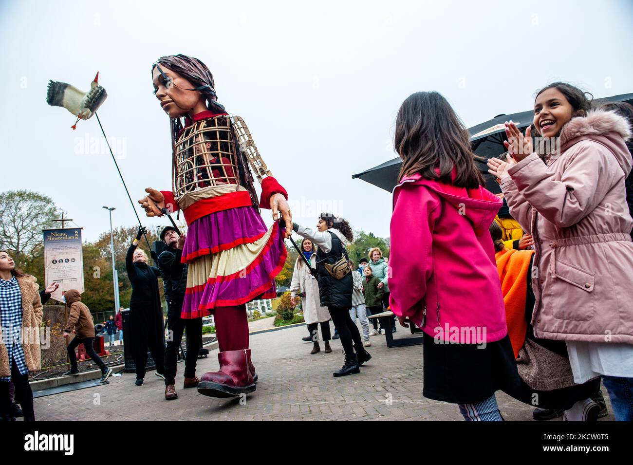 The giant puppet 'Little Amal', a nine-year-old Syrian refugee girl and over 11-feet-tall is dancing with the music of the Syrian singer from the TV show The Voice, Hanin Al Kadamani, inside of the miniature park, Madurodam, in The Hague, on November 15th, 2021. (Photo by Romy Arroyo Fernandez/NurPhoto) Stock Photo
