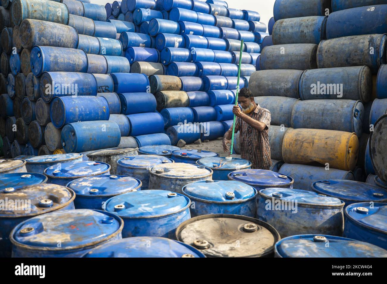 A worker stack empty oil drums for recycling at a warehouse in