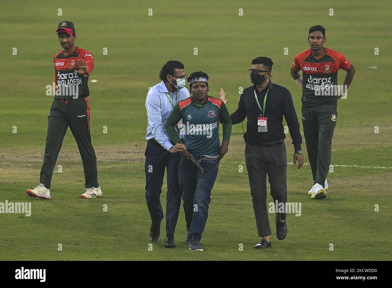 A security official removes a supporter of Bangladesh from the cricket pitch during the second Twenty20 international cricket match between Bangladesh and Pakistan at the Sher-e-Bangla National Cricket Stadium in Dhaka on November 20, 2021. (Photo by Ahmed Salahuddin/NurPhoto) Stock Photo
