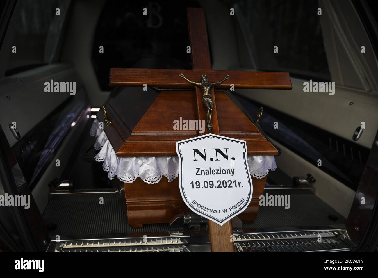 A coffin and a crucifix with NN plate are seen during a funeral of an unknown man, probably a migrant, who was found dead in a forest on September 19th by Polish-Belarusian border. Sokolka, Poland on November 22, 2021. A man was buried at the catholic cemetery but a priest did not conduct funeral rites as there was no evidence of what was the denomination of the deceased, despite a Holy Bible was found by the body. (Photo by Beata Zawrzel/NurPhoto) Stock Photo