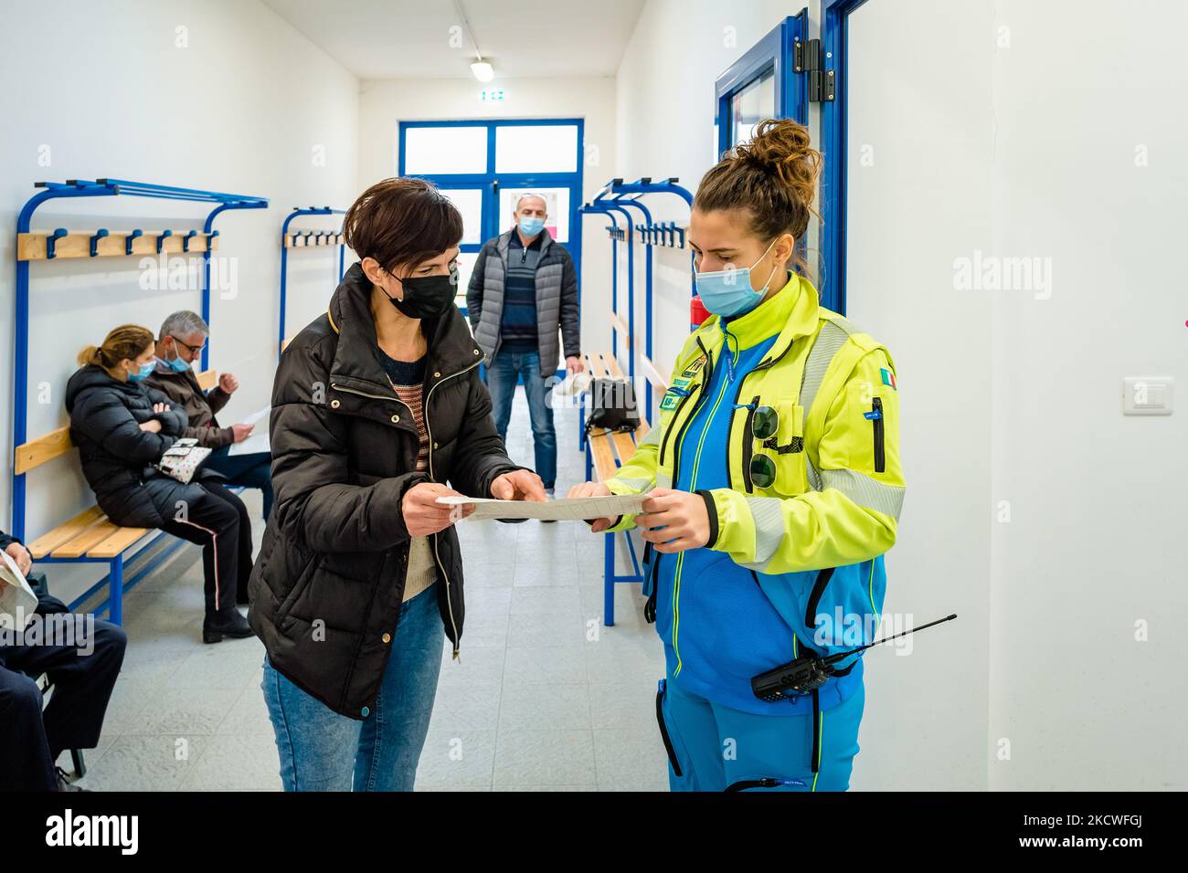 A lady from the health staff asks a volunteer for information after having received the anticovid vaccine at the Cozzoli vaccination hub in Molfetta on November 24, 2021. From 23 November morning, even in Puglia, all over 40s can get vaccinated with the third anti Covid dose if at least six months have passed since the administration of the second or only dose. The Region, to speed up the vaccination campaign, has decided to give the possibility to show up in the hubs even without a reservation. The day of Wednesday 24 November was dedicated to the over 40s who are among health workers, law en Stock Photo
