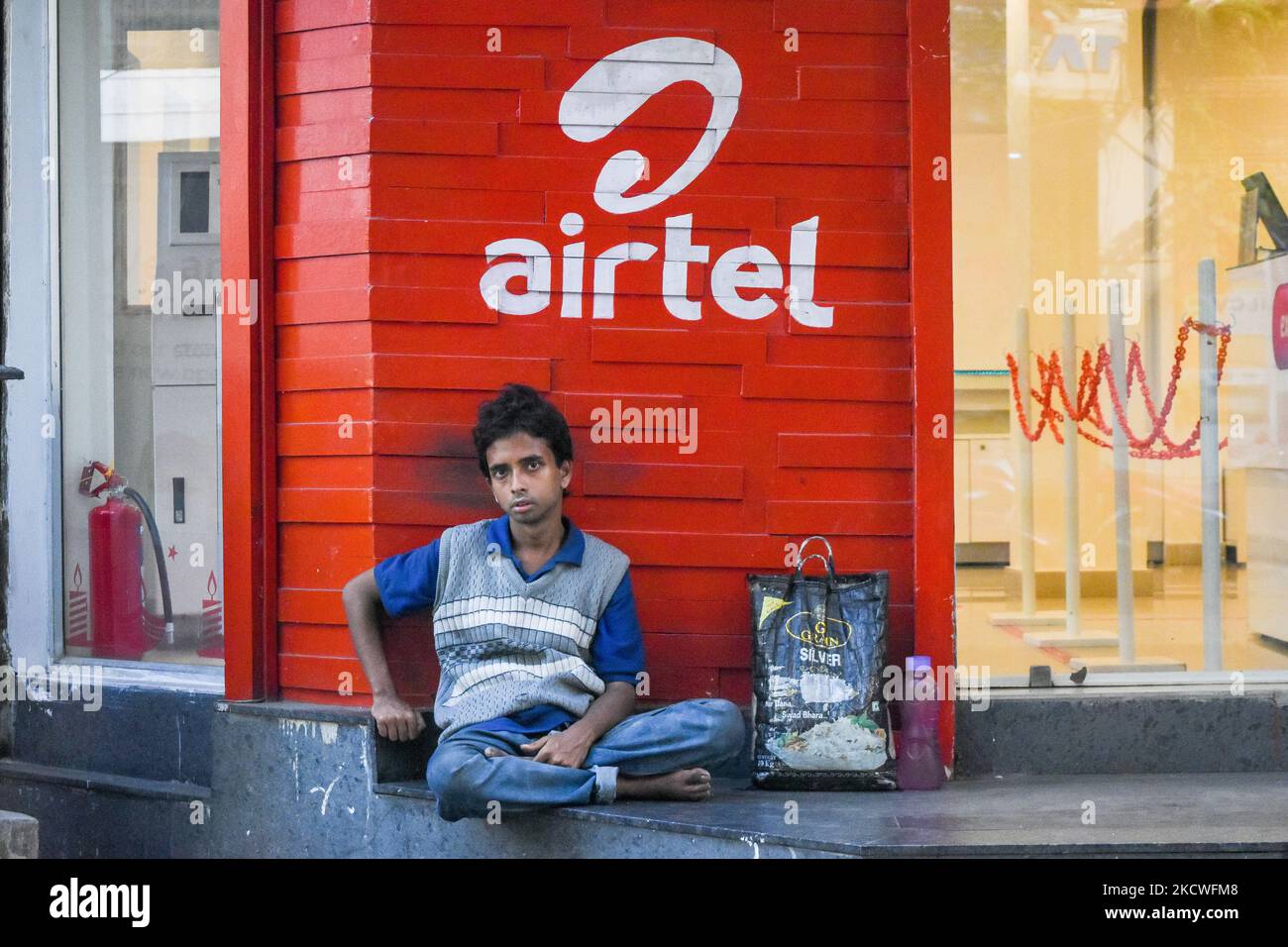 A man is seen sitting in front of an Airtel logo , in Kolkata , India , on 24 November 2021 . Bharti Airtel has announced that they will hike prepaid charges by as much as 25 % on Monday . The Indian telecom giant made this announcement as they add over 3 Lakh subscriber in September quarter . (Photo by Debarchan Chatterjee/NurPhoto) Stock Photo