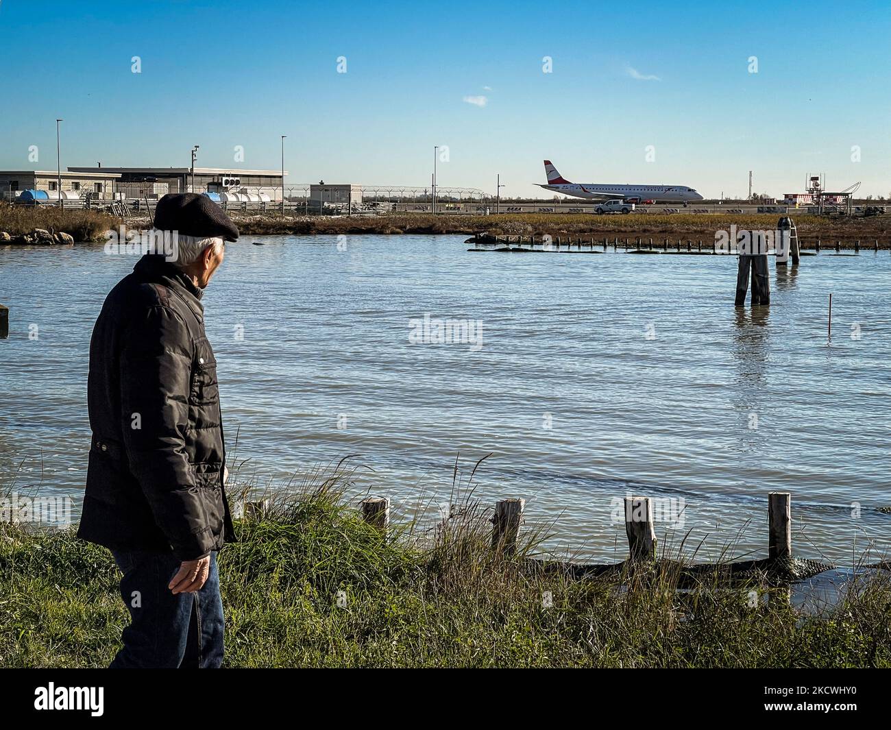 An elderly man watch the departure of an aircraft, in Venice, Italy, on November 24, 2021. (Photo by STR/NurPhoto) Stock Photo