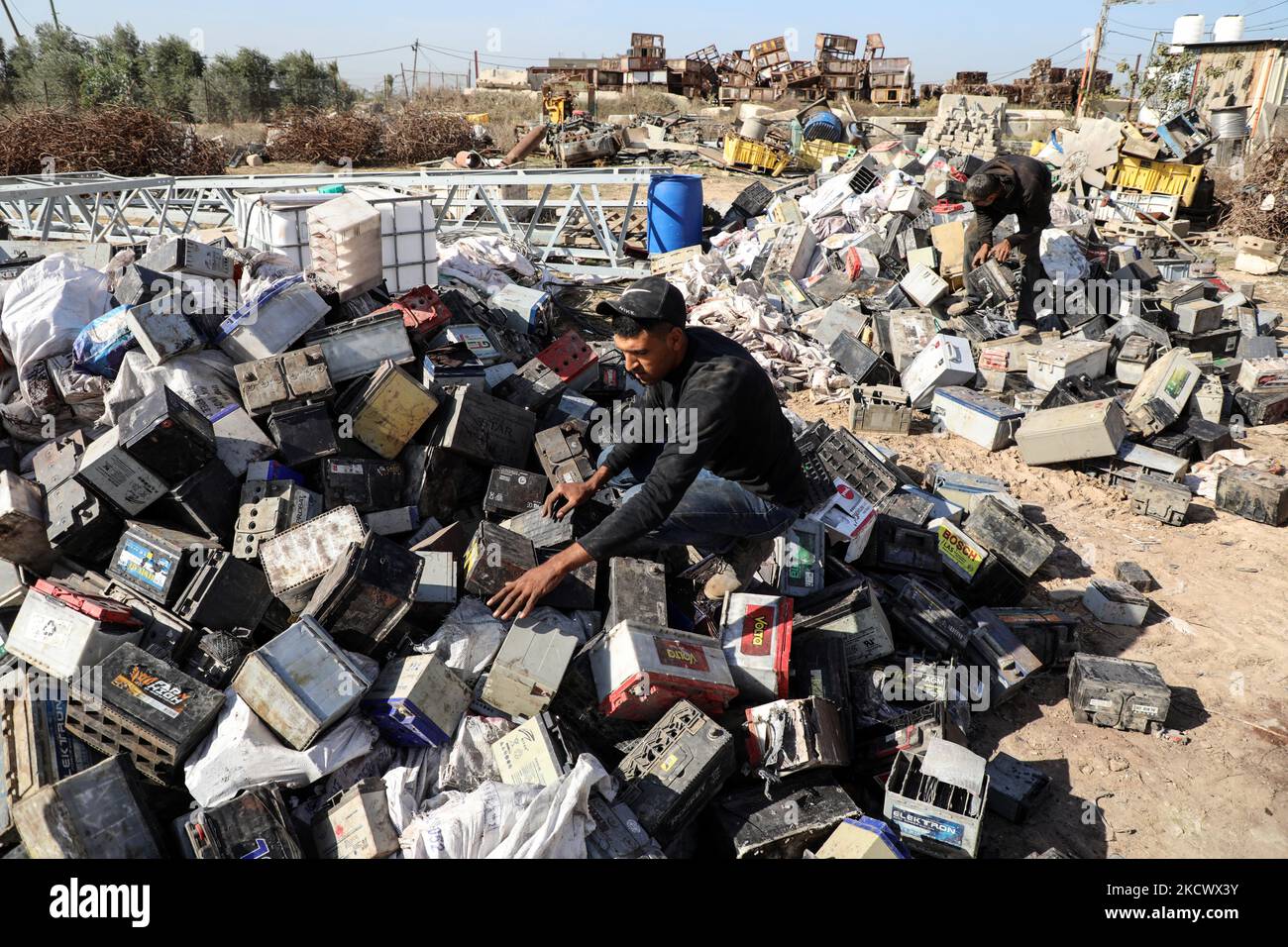 Palestinian workers sort through electronic waste such as batteries, a popular product in the midst of Gaza’s electricity crisis, with the aim of exporting them to Israel for recycling as no such means are available in Gaza City, on November 29, 2021. (Photo by Majdi Fathi/NurPhoto) Stock Photo