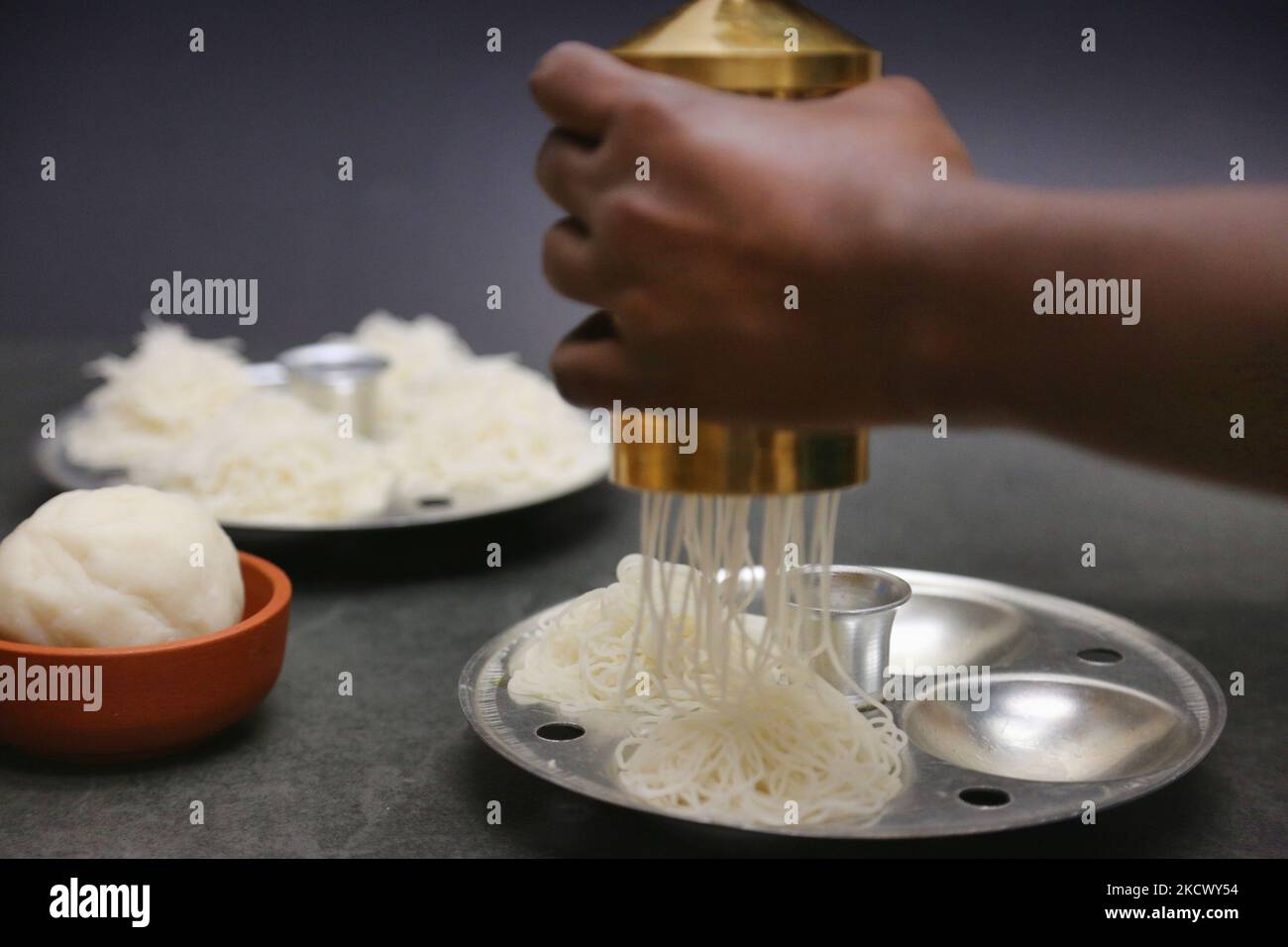 https://c8.alamy.com/comp/2KCWY54/woman-preparing-idiyappam-in-toronto-ontario-canada-on-november-28-2021-idiyappam-also-known-as-string-hoppers-is-a-rice-dish-originating-from-the-indian-states-of-tamil-nadu-and-kerala-it-consists-of-rice-flour-pressed-into-noodles-woven-into-a-flat-disc-like-shape-and-steamed-photo-by-creative-touch-imaging-ltdnurphoto-2KCWY54.jpg