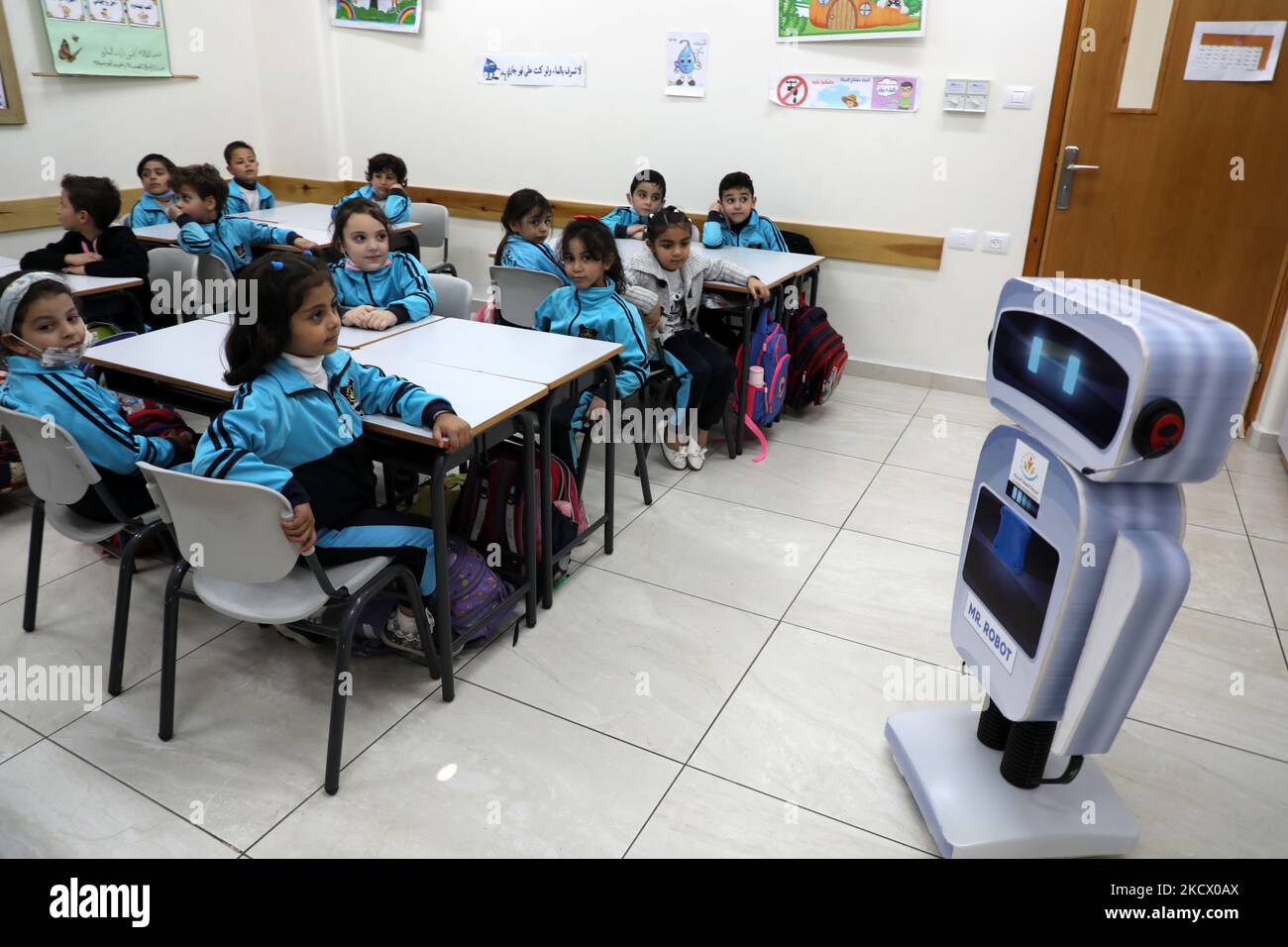 Palestinian students interact with a locally-made educational robot during a science class at a private school in Gaza City on November 30, 2021. (Photo by Majdi Fathi/NurPhoto) Stock Photo