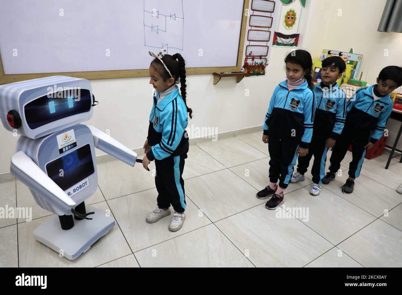 Palestinian students interact with a locally-made educational robot during a science class at a private school in Gaza City on November 30, 2021. (Photo by Majdi Fathi/NurPhoto) Stock Photo