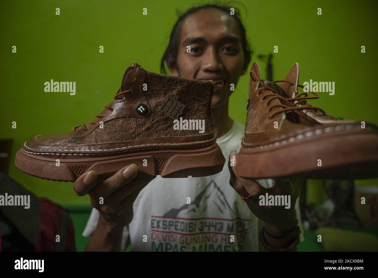 Imran, a small business actor shows shoes made of bark in Sidera Village, Sigi Regency, Central Sulawesi Province, Indonesia on November 29, 2021. Products made from bark that have been used by indigenous people in the local area have begun to be abandoned and shifted to to synthetic products. Imran makes innovations by designing various products from bark such as bags, shoes, shirts, backpacks to watches. The innovation is carried out so that the preservation of local cultural values ??in the region can be maintained. These innovative products are currently not mass-produced to avoid clearing Stock Photo