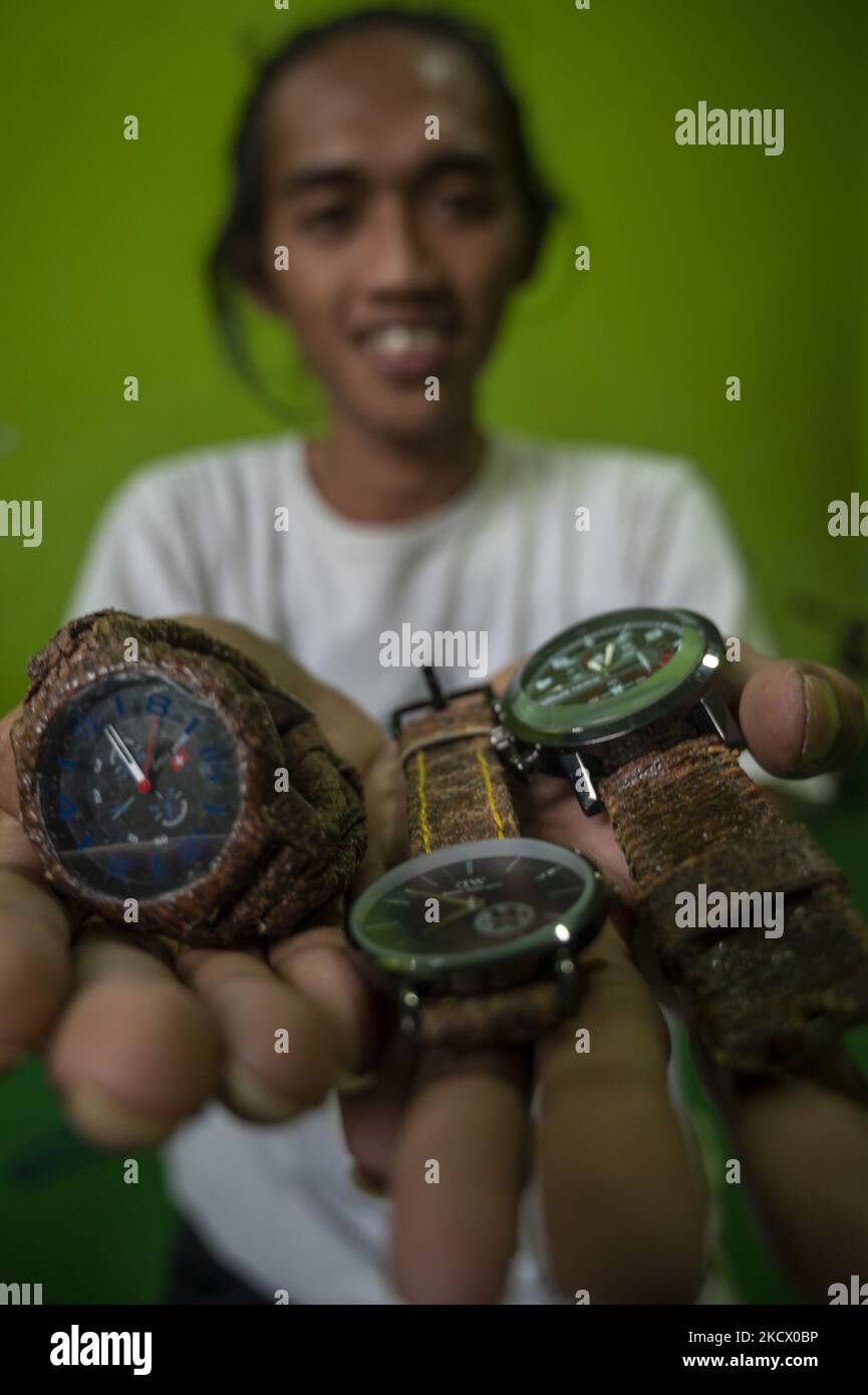 Imran, a small business actor shows a watch made of bark in Sidera Village, Sigi Regency, Central Sulawesi Province, Indonesia on November 29, 2021. Products made from bark that have been used by indigenous people in the local area have begun to be abandoned and shifted to to synthetic products. Imran makes innovations by designing various products from bark such as bags, shoes, shirts, backpacks to watches. The innovation is carried out so that the preservation of local cultural values ??in the region can be maintained. These innovative products are currently not mass-produced to avoid cleari Stock Photo