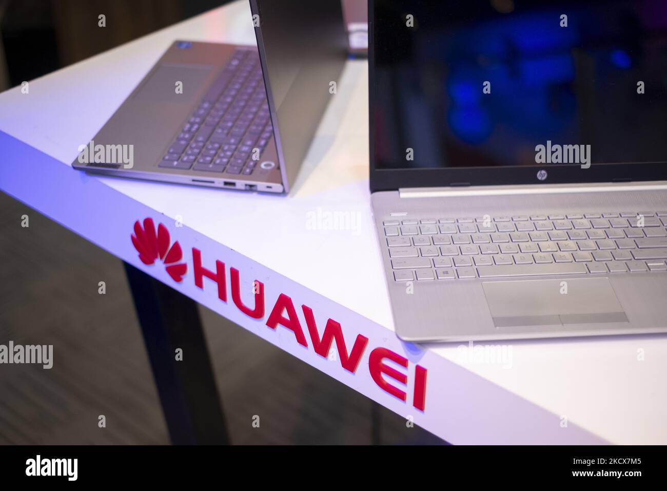 A logo of the Huawei Chinese company is seen on a desk next to a laptop of the HP American company in an IT-City multi brand shop at the Paytakht computer centre in northern Tehran on December 2, 2021. Despite US sanctions against Iran, Iranians have access to the latest technology in the world of telecommunications and digital, but in most cases at a higher price than the global value of technology goods, but the Iranians prefer to keep themselves update themselves in the field of the computers and telecommunication technology. Even though they have to have to get loan to buy a new smartphone Stock Photo