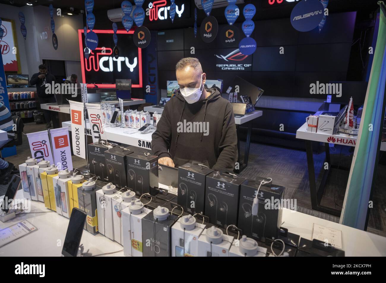 An Iranian salesman wearing a protective face mask works with a laptop in an IT-City multi brand shop at the Paytakht computer centre in northern Tehran on December 2, 2021. Despite US sanctions against Iran, Iranians have access to the latest technology in the world of telecommunications and digital, but in most cases at a higher price than the global value of technology goods, but the Iranians prefer to keep themselves update themselves in the field of the computers and telecommunication technology. Even though they have to have to get loan to buy a new smartphone like the iPhone 13. (Photo  Stock Photo