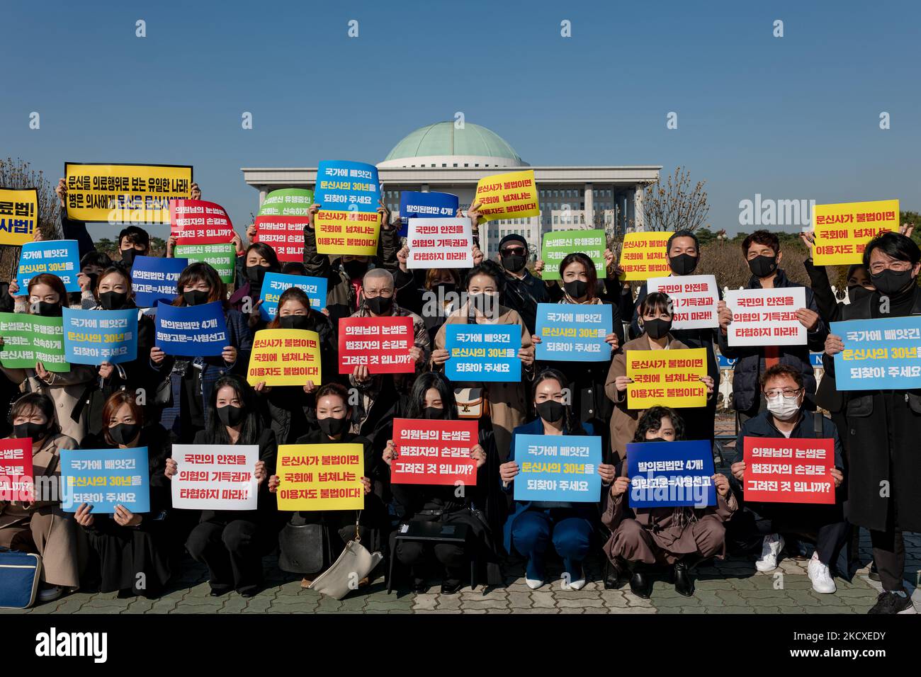 Members of the Korean Association of Tattoo Artists hold placards at the contest to urge the enactment of the tattoo law in front of the Yeouido National Assembly on December 08, 2021 in Seoul, South Korea. In South Korea, it is considered illegal medical practice if those who are not doctors under the current medical law perform tattoos. The tattooists have filed three constitutional wishes since 2017, and it is said that the court is currently under consideration. (Photo by Chris Jung/NurPhoto) Stock Photo
