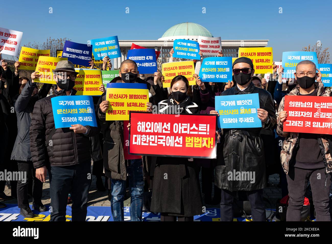 Members of the Korean Association of Tattoo Artists hold placards at the contest to urge the enactment of the tattoo law in front of the Yeouido National Assembly on December 08, 2021 in Seoul, South Korea. In South Korea, it is considered illegal medical practice if those who are not doctors under the current medical law perform tattoos. The tattooists have filed three constitutional wishes since 2017, and it is said that the court is currently under consideration. (Photo by Chris Jung/NurPhoto) Stock Photo
