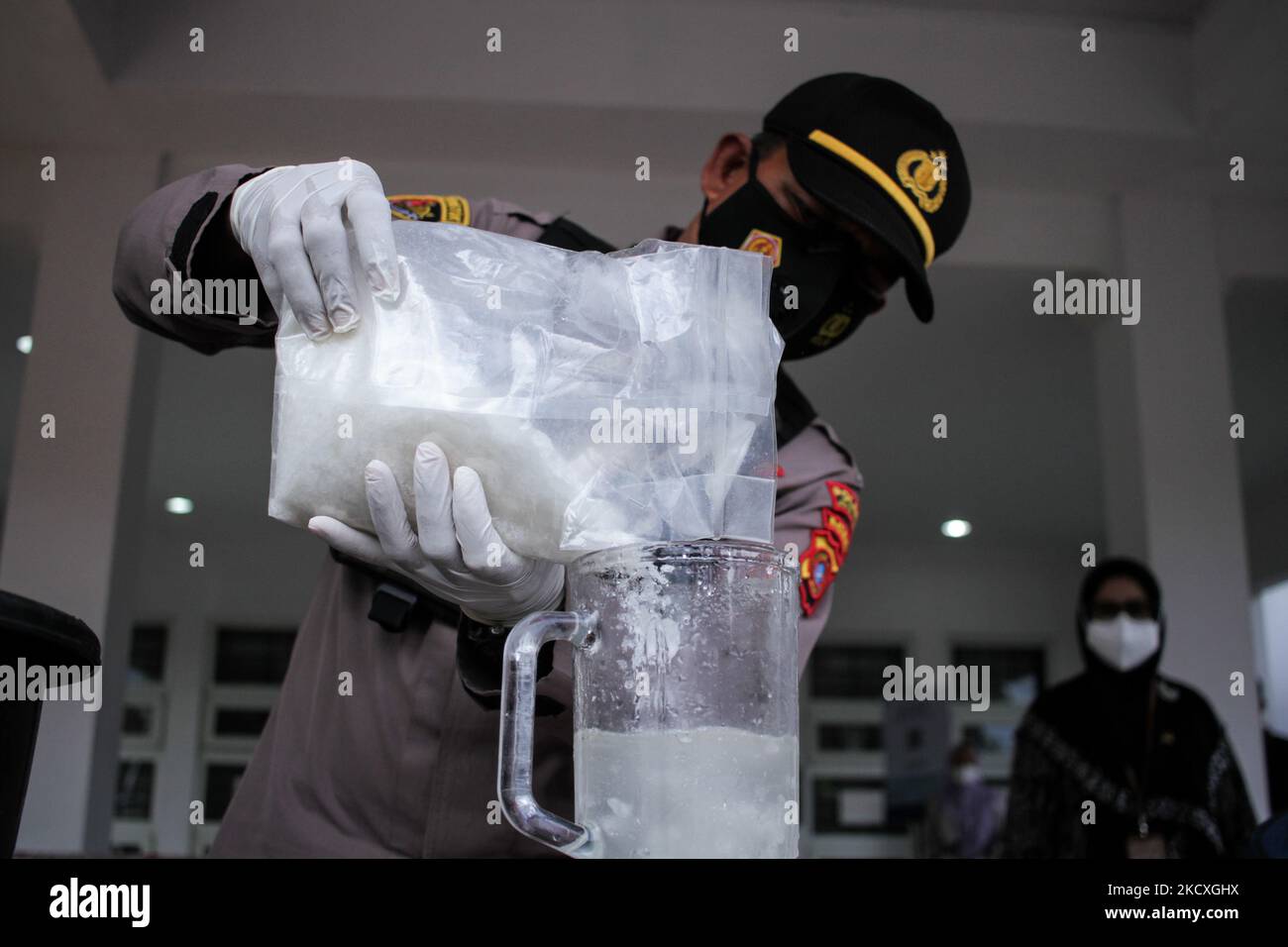 An officer from the Prosecutor's Office and the Police is seen destroying evidence of 5.85 Kilograms of methamphetamine in a blender and mixed with water and oil, at a press conference in North Aceh, On December 9, 2021, Aceh Province, Indonesia. The North Aceh District Prosecutor's Office at a press conference destroyed evidence in the form of methamphetamine for the second time from a number of cases throughout 2021 that occurred in the jurisdiction of North Aceh Regency. (Photo by Fachrul Reza/NurPhoto) Stock Photo