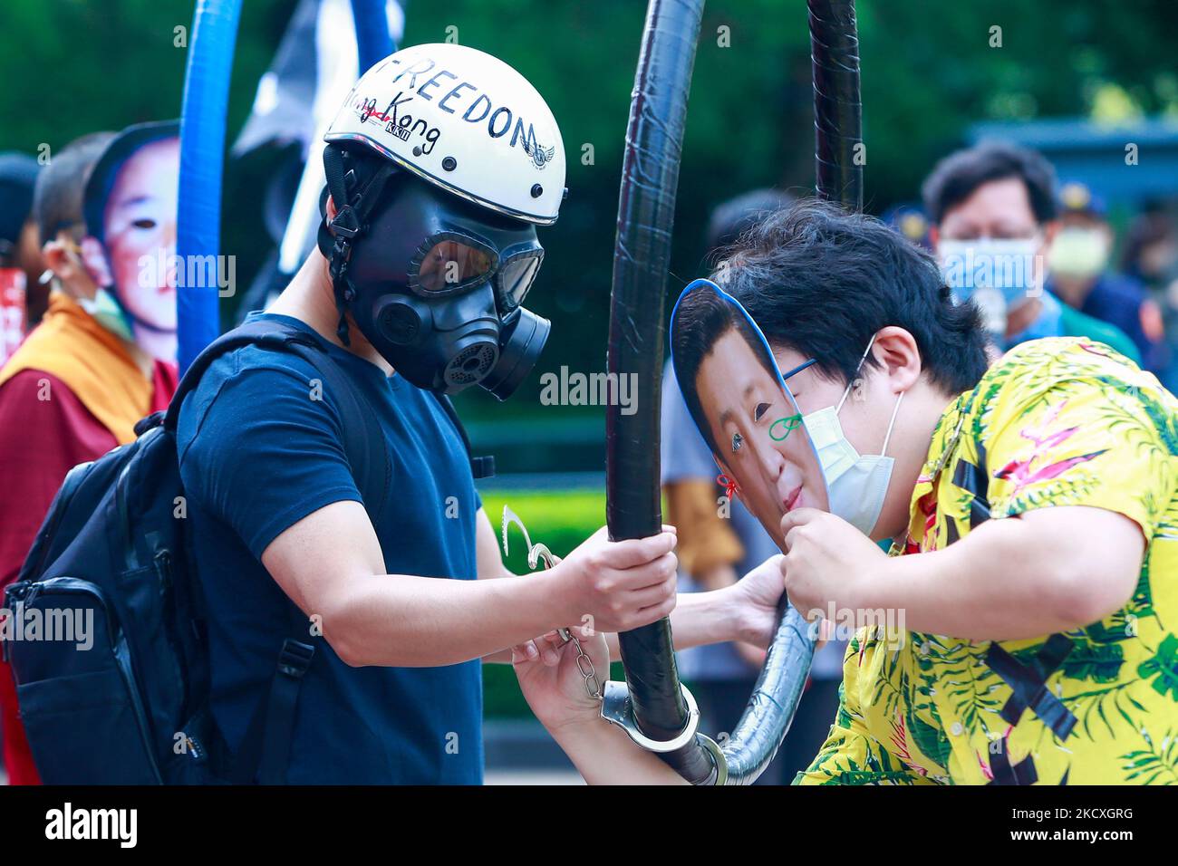 A protester wearing a mask with the face of Chinese president Xi Jinping handcuffs a protester with a respirator, during a protest boycotting the Beijing Winter Games 2022, outside the Bank of China (Taipei Branch), in Taipei, Taiwan, 10 December 2021. The United States, Canada, UK, and Australia have pledged not to send officials to attend the Games as a mean to boycott the China, following the disappearance of Chinese tennis player Peng Shuai and human rights crackdowns on Hong Kong and Xinjiang. (Photo by Ceng Shou Yi/NurPhoto) Stock Photo