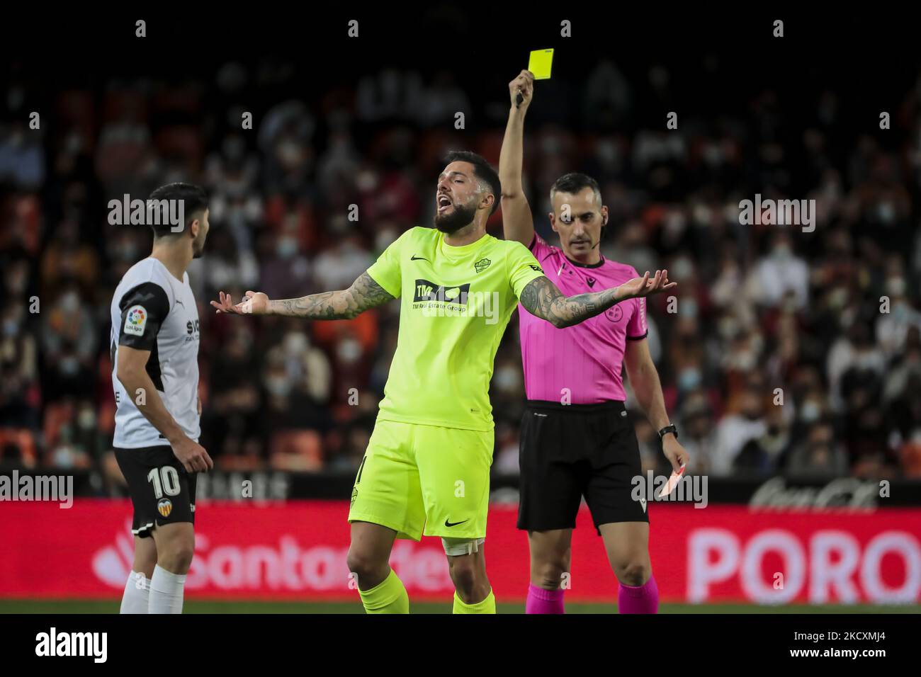 Jaime Latre show yellow card to Tete Morente of Elche CF during La Liga match between Valencia CF and Elche CF at Mestalla Stadium on December 11, 2021. (Photo by Jose Miguel Fernandez/NurPhoto) Stock Photo