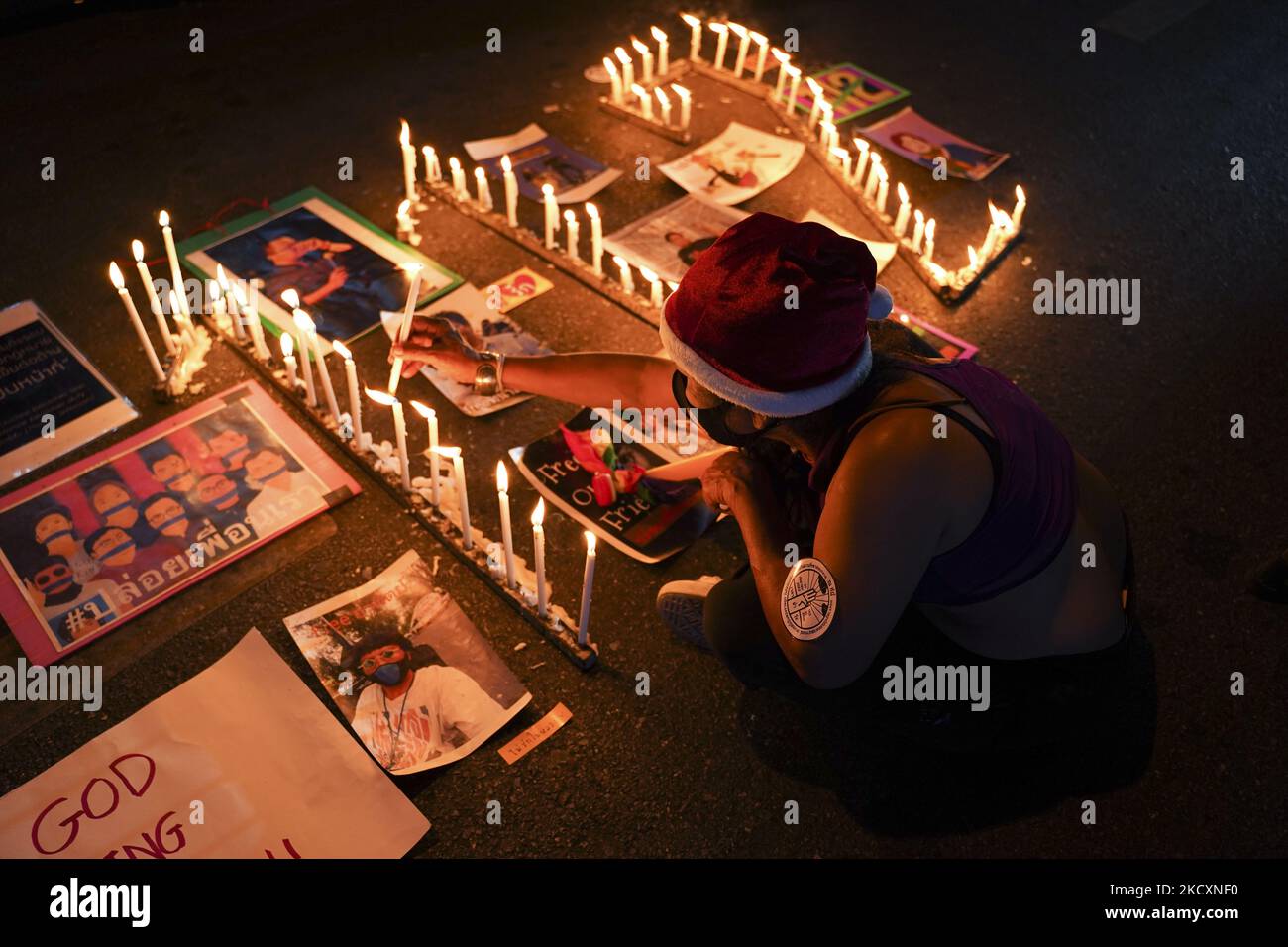 Protester lit candles spelling out '112' stand among pictures of detained political activists during a demonstration calling for the abolition of the section 112 criminal code lese majeste law in Bangkok, Thailand, 12 December 2021. (Photo by Anusak Laowilas/NurPhoto) Stock Photo