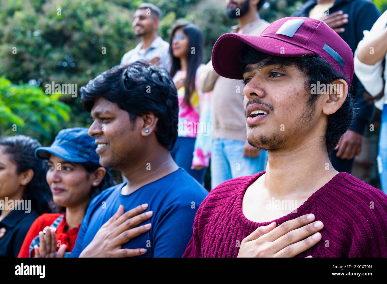 side view shot of spectators or audience singing national anthem at stadium before match - concept of nationalism, independence and sports tournament Stock Photo