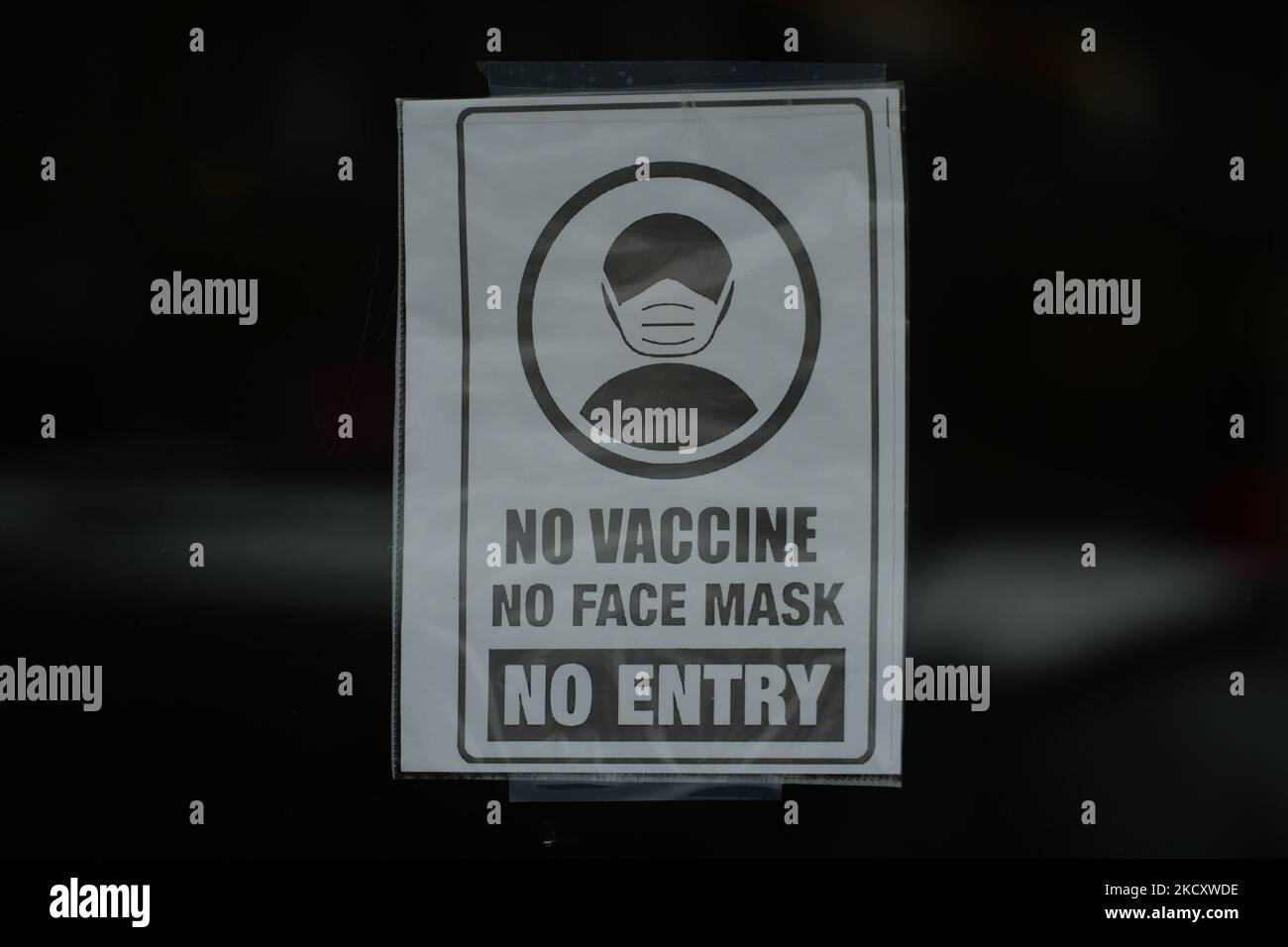 Sign 'No Vaccine, No Mask, No Entry' seen on the door of a store on