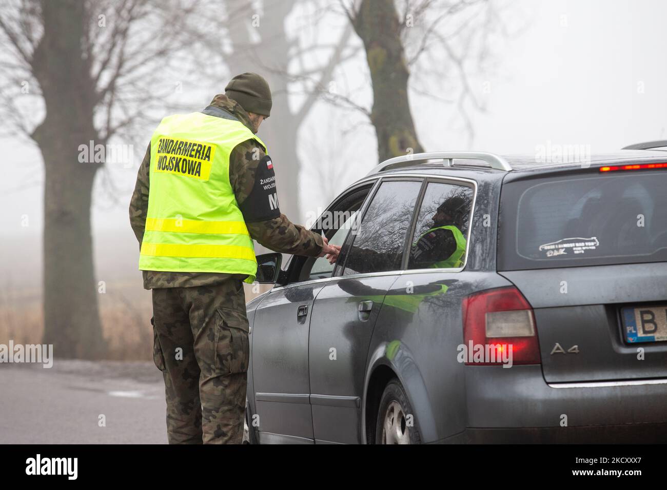 Polish Border Guards at the military checkpoint check ID’s of drivers who wish to enter the a security zone by the Belarusian border near Kuznica, Poland on December 15, 2021. Polish government annonced no entry zone by Polish-Bielarus border due to an infaux of immigrants, mainly from the Middle East. The border between Belarus and Poland is also the border of the European Union. Poland accuses the Lukashenko regime of orchestrating the transit of thousands of migrants from the Middle East to put pressure on the EU. Due to the crisis the EU proposed new border laws which jeopardise itd free m Stock Photo