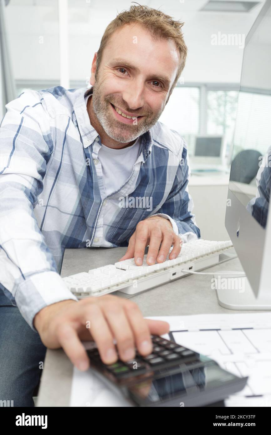 man uses a calculator with keyboard Stock Photo - Alamy