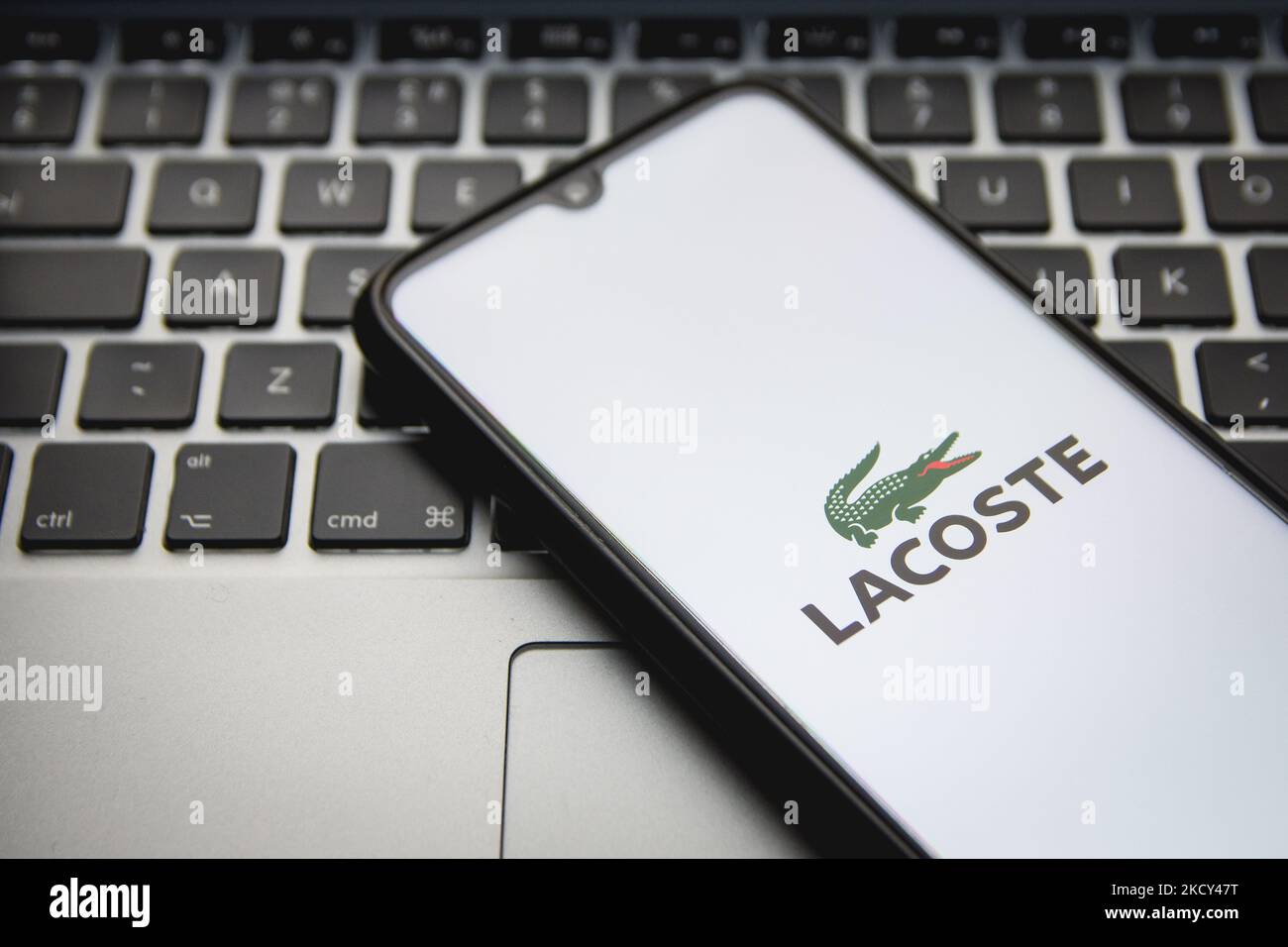 In this photo illustration a Lacoste logo seen displayed on a smartphone screen with a computer keyword in the background in Athens, Greece on December 18, 2021. (Photo by Nikolas Kokovlis/NurPhoto) Stock Photo
