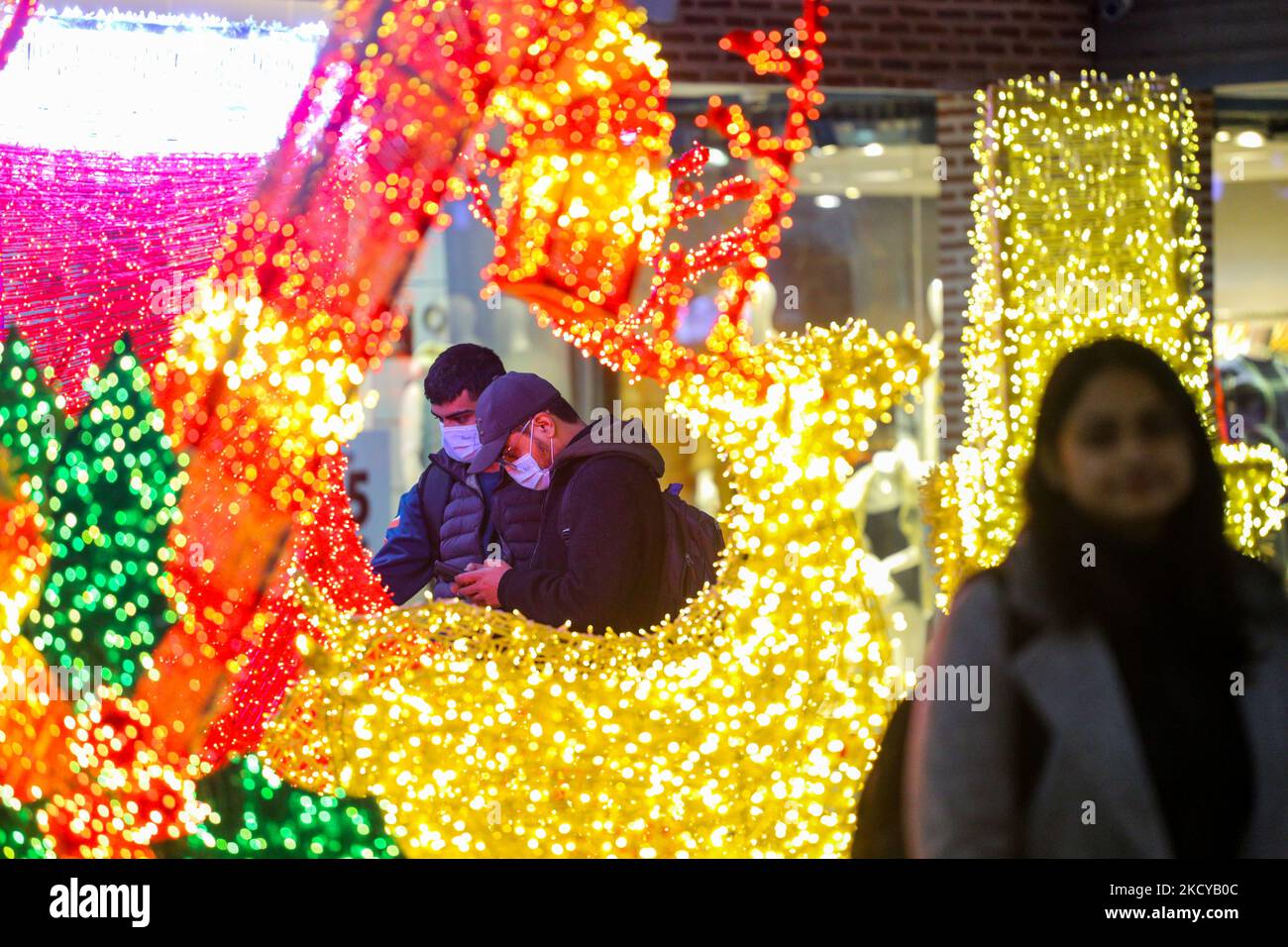 People enjoy Christmas lights and decorations at the shopping mall