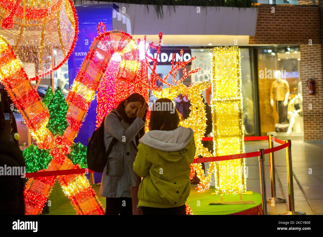 People enjoy Christmas lights and decorations at the shopping mall