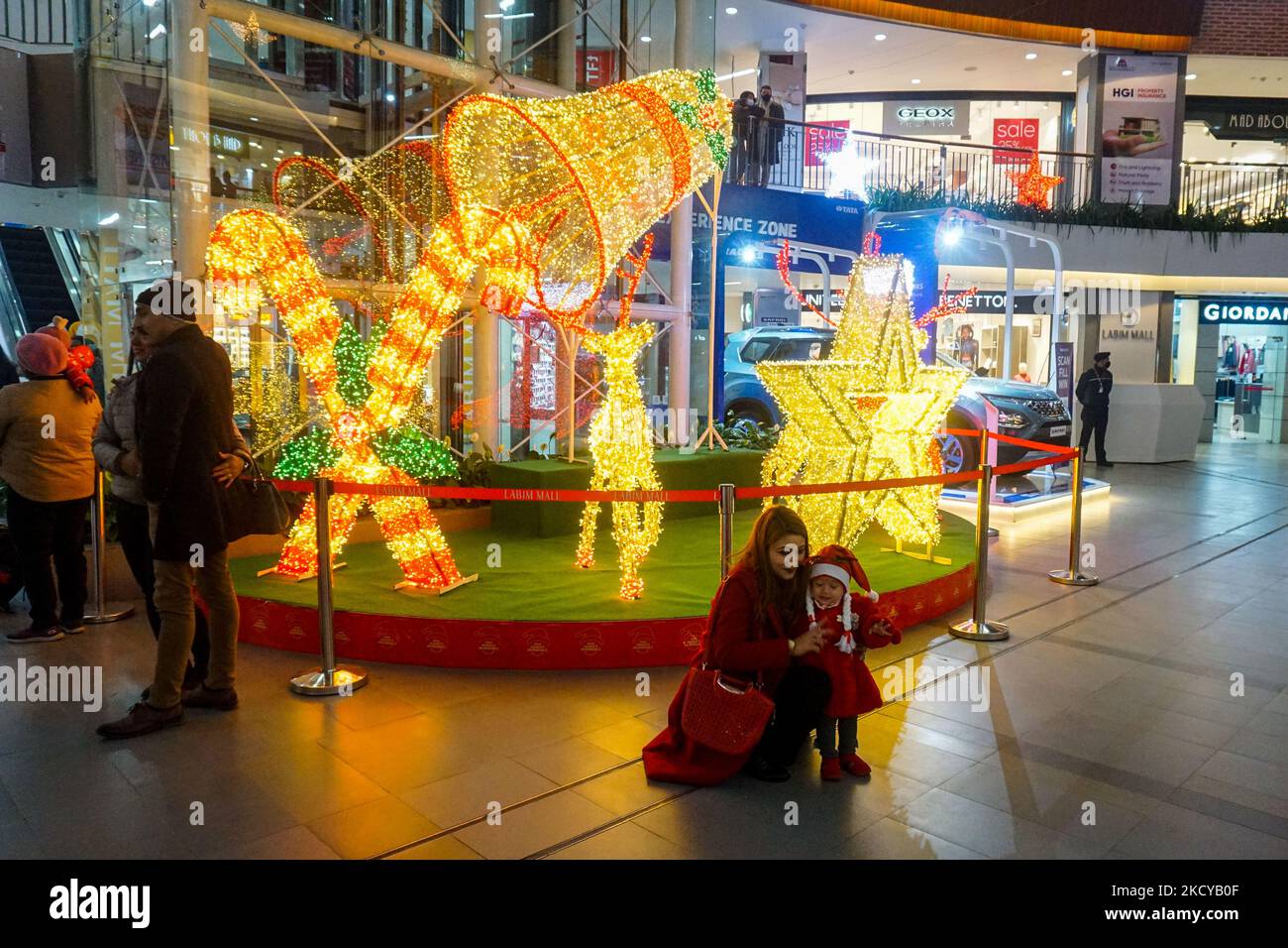 People enjoy Christmas lights and decorations at the shopping mall