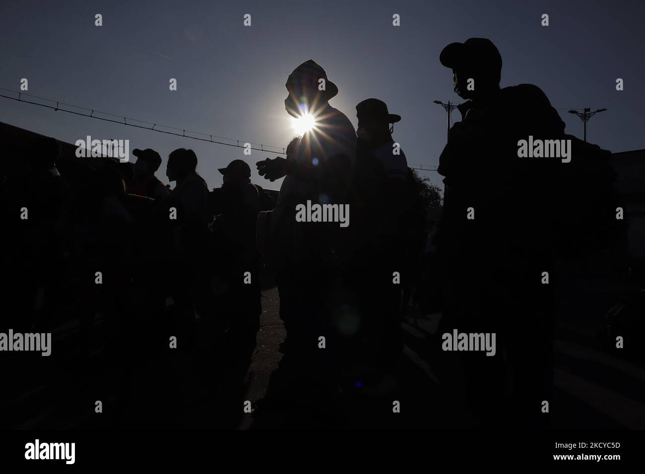 Backlit members of the migrant caravan in the car park of the Casa Peregrino, Mexico City, wait to board several buses that will take them to the north of Mexico where they will continue with the processing of their humanitarian visas after negotiations and agreements with the Mexican government. (Photo by Gerardo Vieyra/NurPhoto) Stock Photo