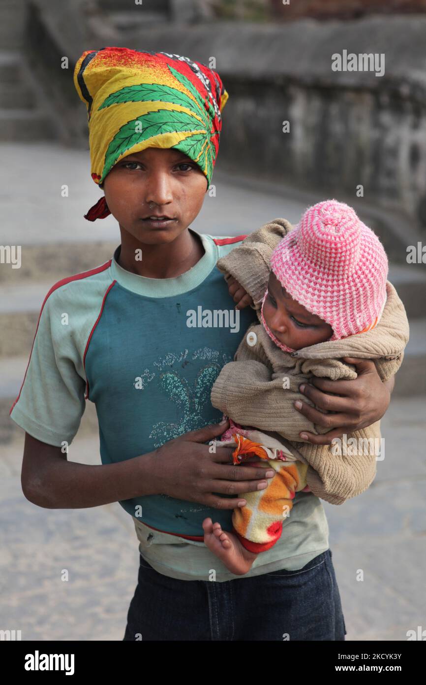 Boy holds his baby sister as he begs on the streets of Kathmandu City, Nepal. Poverty and child labour are two important issues facing Nepal. (Photo by Creative Touch Imaging Ltd./NurPhoto) Stock Photo