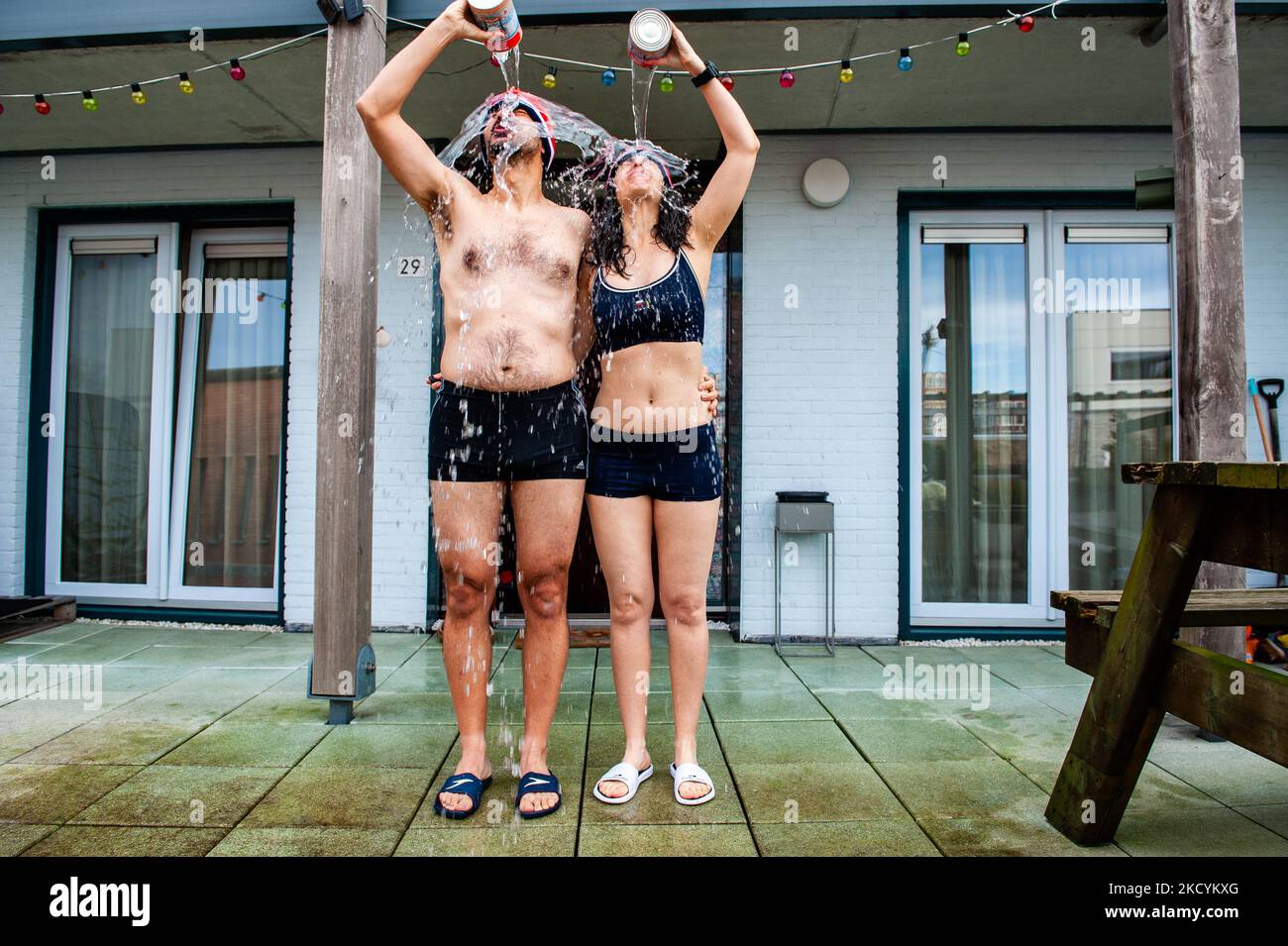 A couple is throwing to themselves cans filled with seawater during the celebration of the traditional New Year's dive again at home because of the pandemic. In Nijmegen, on January 1st, 2021. (Photo by Romy Arroyo Fernandez/NurPhoto) Stock Photo