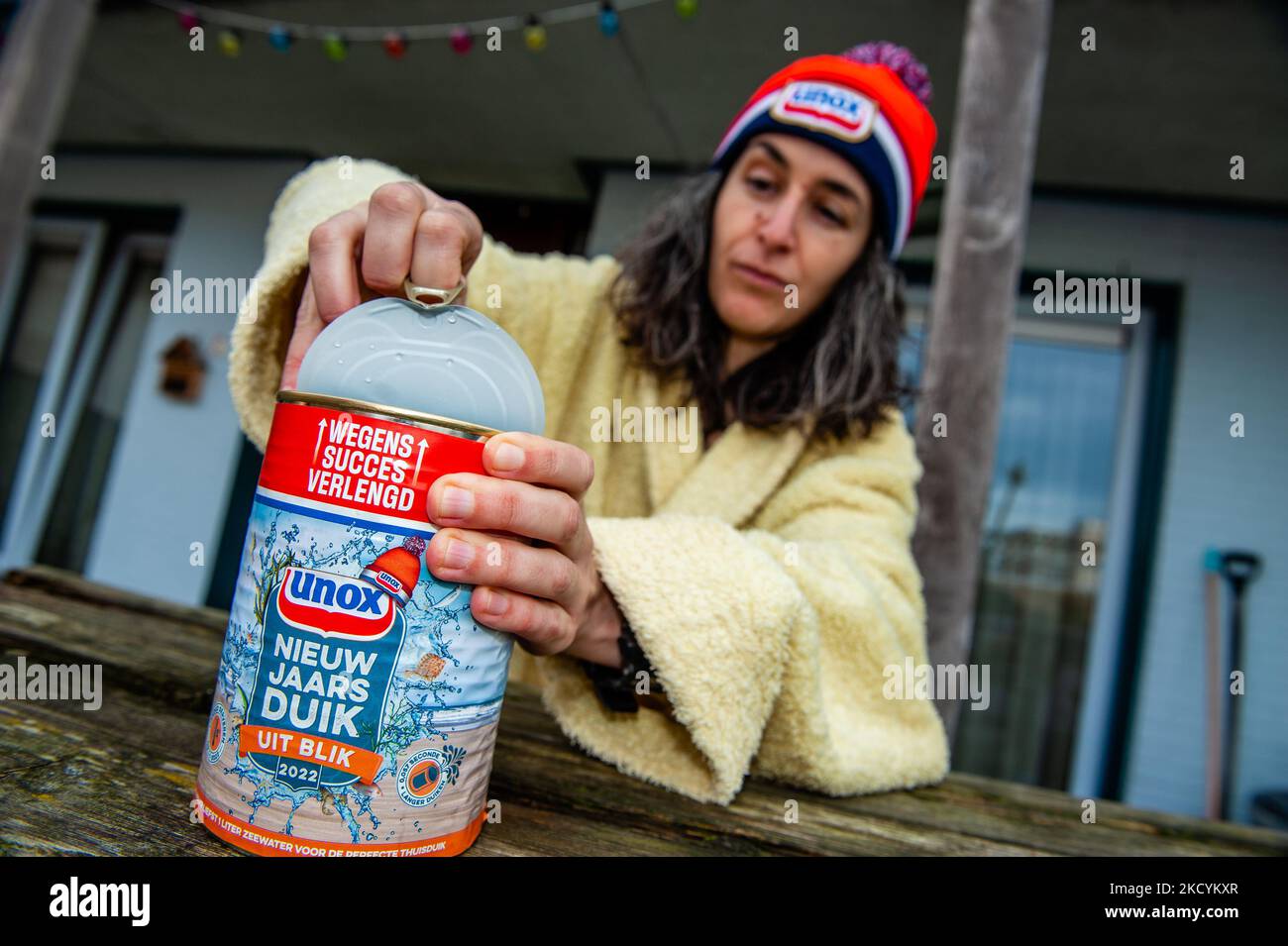 A woman is opening one of the Unox cans filled with seawater during the traditional New Year's dive at home, in Nijmegen, on January 1st, 2021. (Photo by Romy Arroyo Fernandez/NurPhoto) Stock Photo