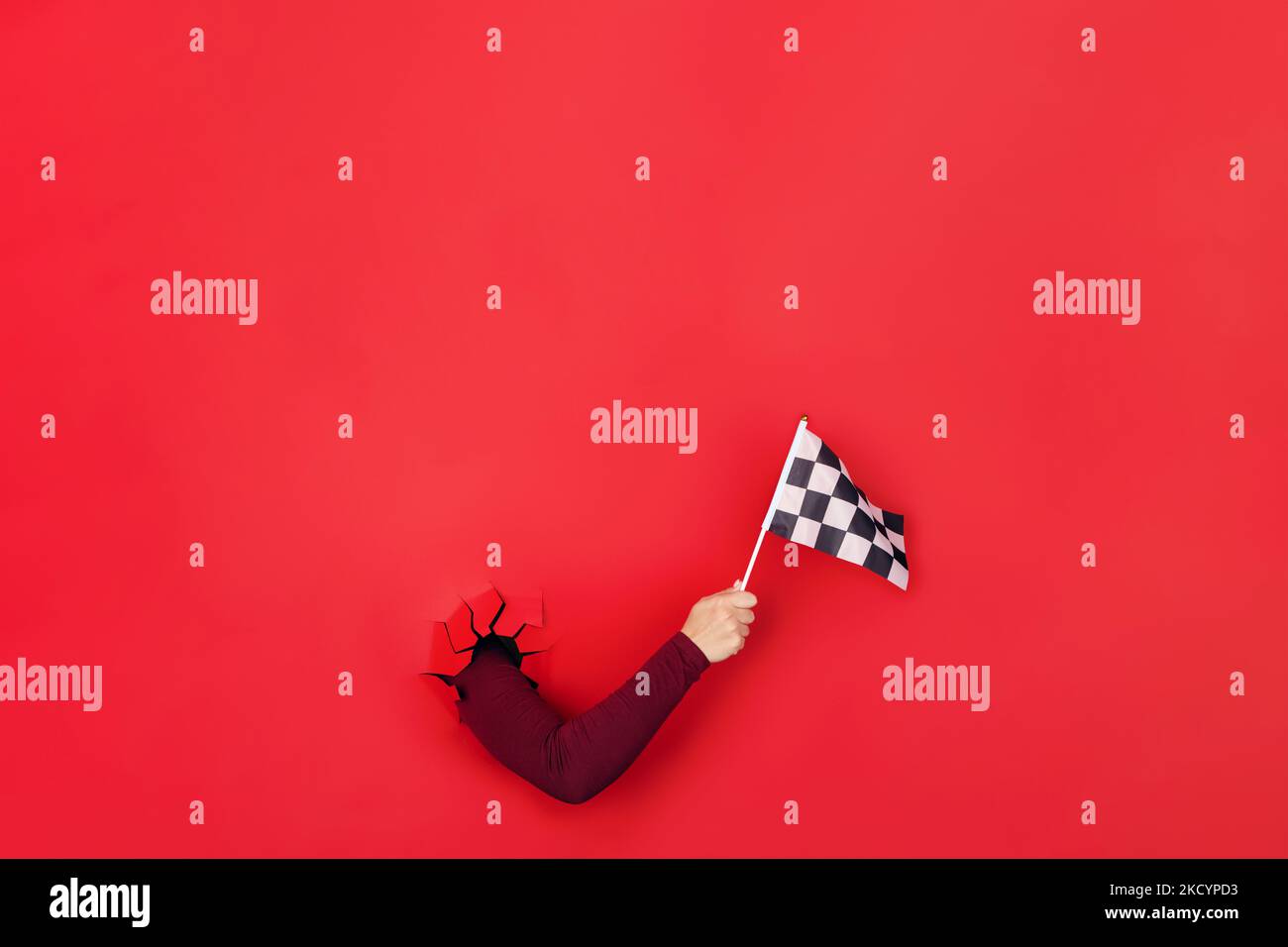 checkered flag in hand over red background, layout image Stock Photo