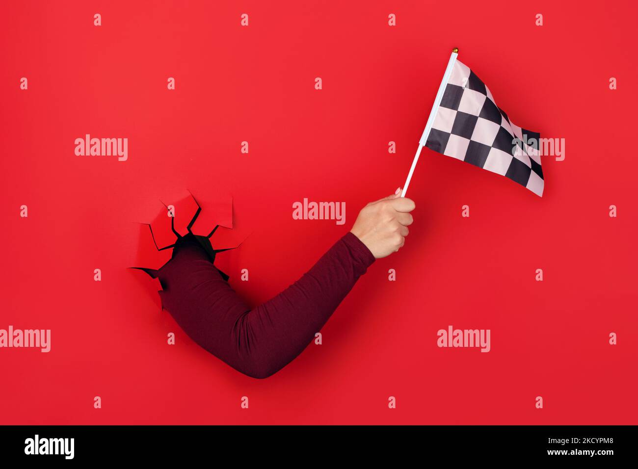 checkered flag in hand over red background Stock Photo