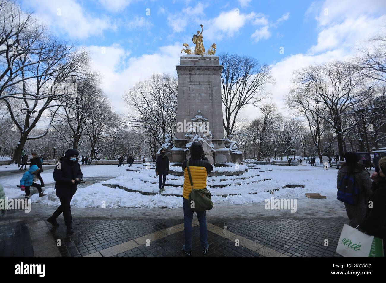 Man use his phone to do a pictures near a status in Central Park