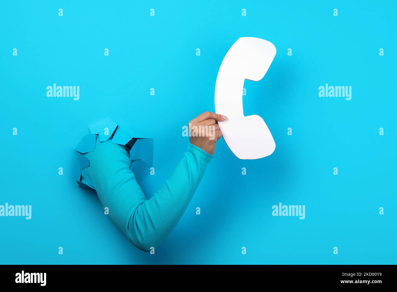 handset in hand over blue background Stock Photo