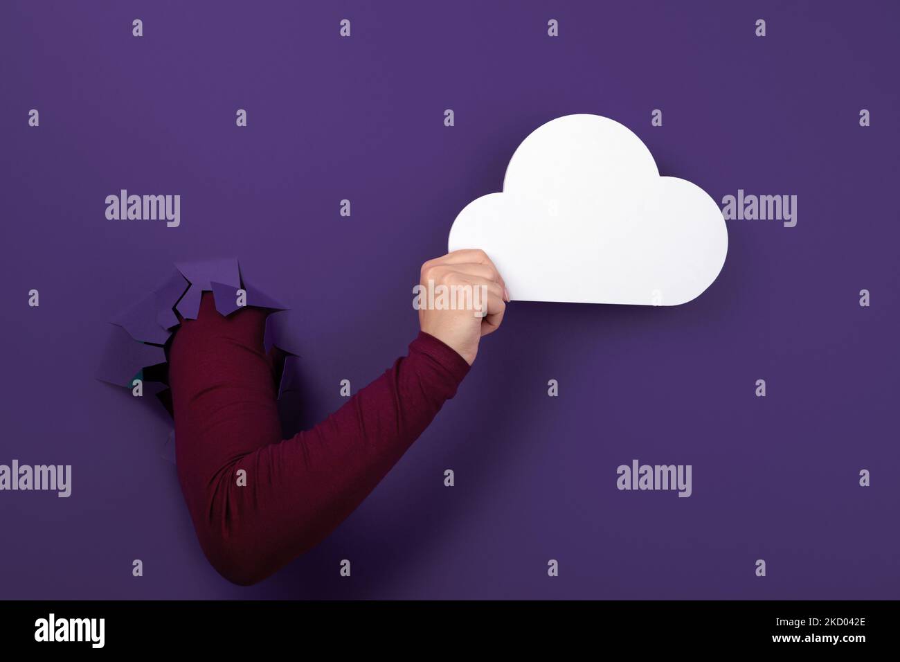 Cloud computing concept, hand holding cloud over purple background, cloud storage Stock Photo