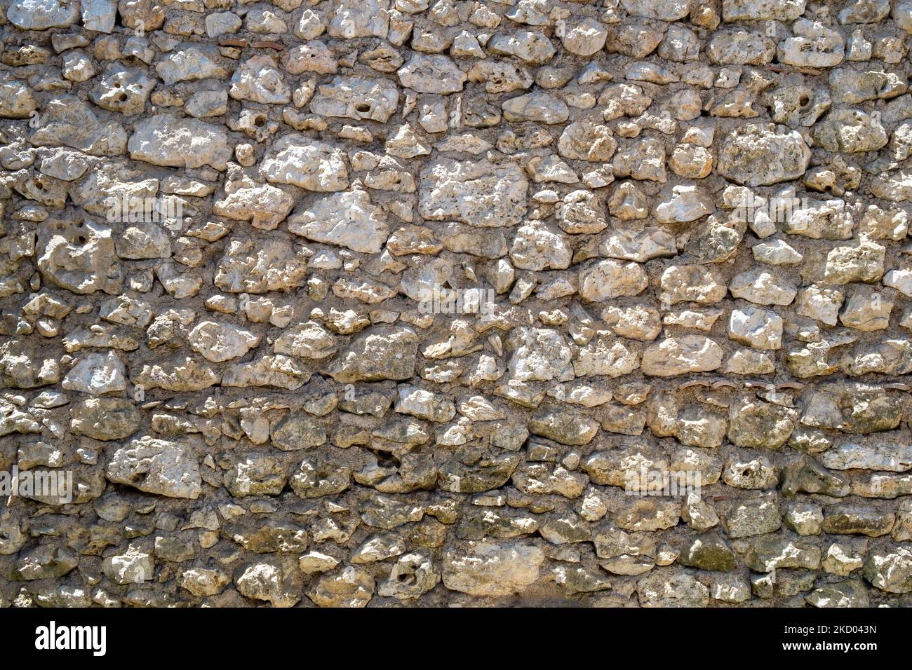 An old rubble stone wall full frame background close up Stock Photo