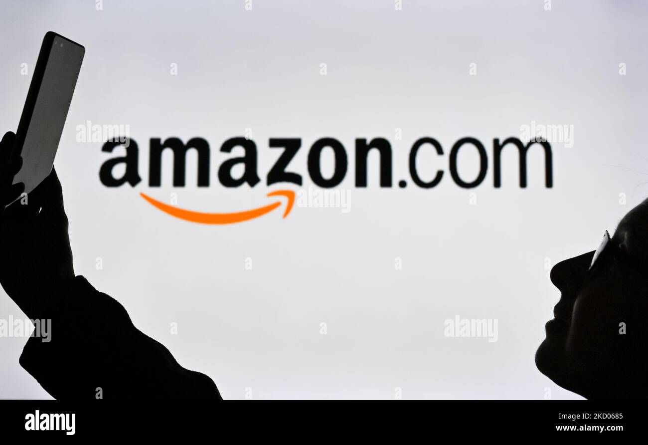 An image of a woman holding a cell phone in front of an logo