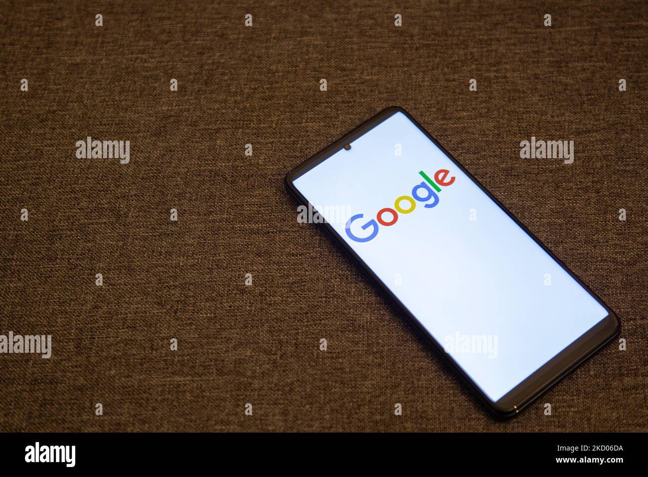 Google closeup logo displayed on a phone screen, smartphone the logo or the search engine in various backgrounds like keyboard, dark illuminated texture or a computer screen, as seen in this multiple exposure illustration, the company's symbol is globally recognized. Google, LLC is an American tech giant, a multinational technology company that specializes in Internet-related services and products, which include online advertising technologies, a search engine, cloud computing, software, and hardware. It is considered one of the Big Four - Big Tech technology companies in the U.S. and globally Stock Photo