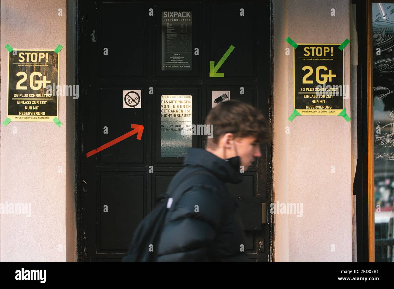 A man walks pass a pub with ''2G plus '' sign ( vaccinated and recovered, plus with tested or boosted) in Cologne, Germany on January 11, 2022 as new restrictions for restaurants and bars are soon going to be imposed in Germany. (Photo by Ying Tang/NurPhoto) Stock Photo