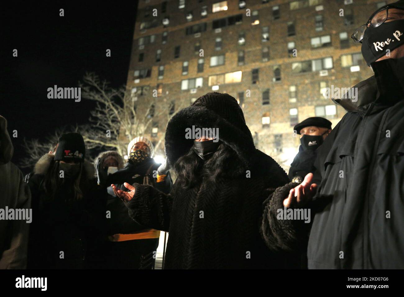 People paray during a vigil in front of a hirise building where