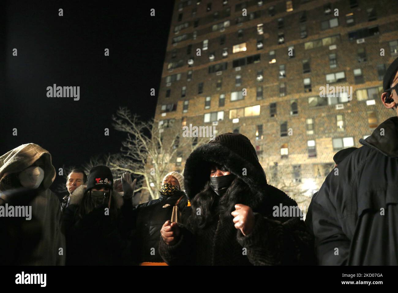 People paray during a vigil in front of a hirise building where