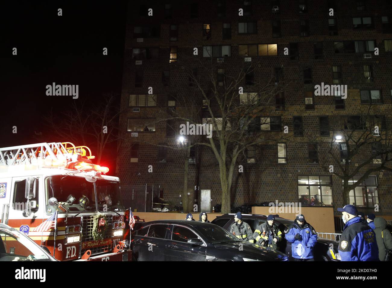 People attend a vigil in front of a hirise building where seventeen