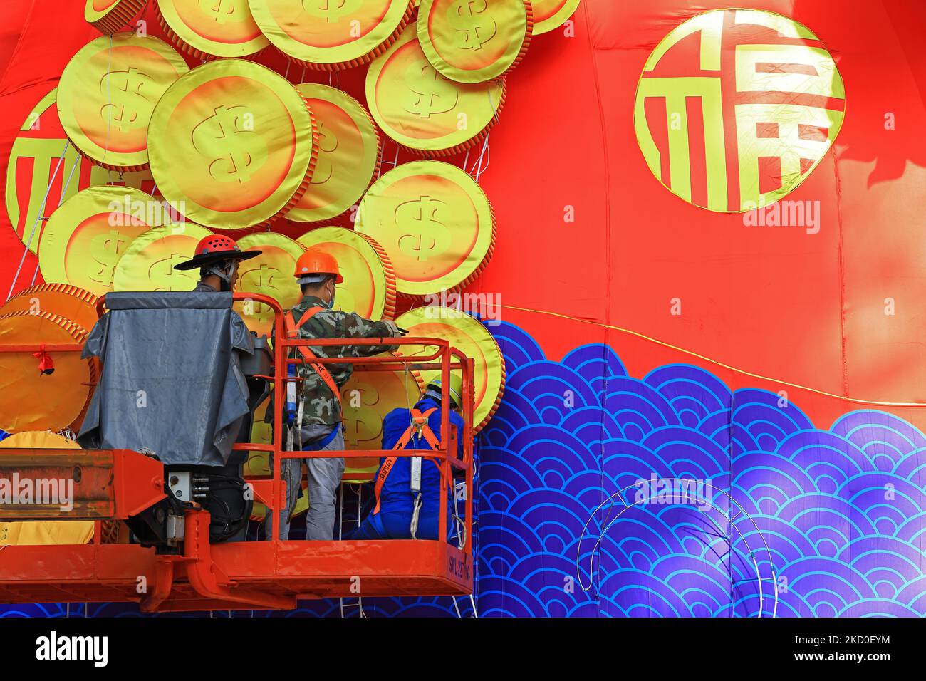 Workers put up decorative gold coins on a giant lantern display featuring the God of Fortune as Singapore prepares to usher in the Year of the Tiger amid the rise in the Omicron variant cases during the COVID-19 pandemic at the Supertree Grove, Gardens by the Bay on January 16, 2022 in Singapore. On February 1, people around the world will welcome the Year of the Tiger, one of the most anticipated holidays on the Chinese calendar. Also known as the Spring festival or the Lunar New Year, the celebrations last for about 15 days. (Photo by Suhaimi Abdullah/NurPhoto) Stock Photo