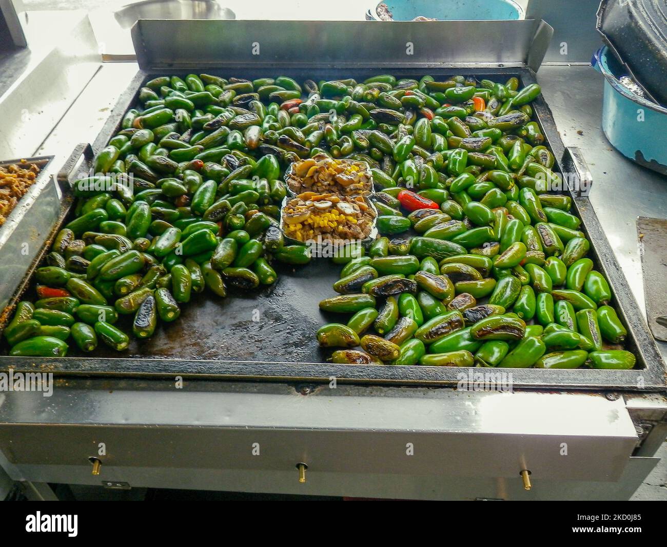 Jalapeno peppers roasting on a large flat grill in Baja California