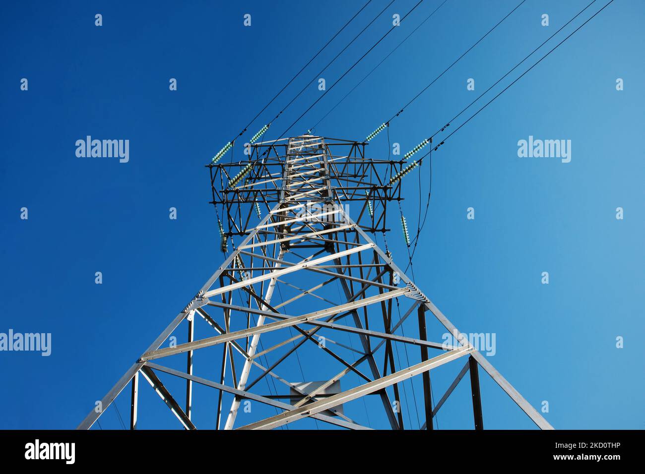 high voltage tower over blue sky, electricity crisis Stock Photo - Alamy