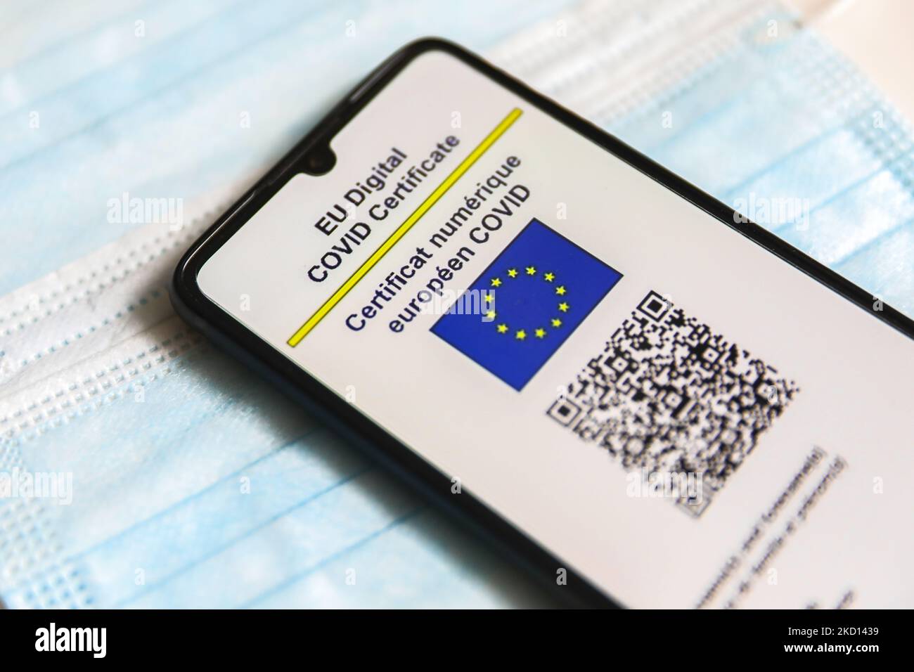 EU Digital COVID Certificate is displayed on a mobile phone screen photographed on surgical masks background for illustration photo during the spread of the fifth wave of the coronavirus pandemic. Gliwice, Poland on January 23, 2022. (Photo by Beata Zawrzel/NurPhoto) Stock Photo