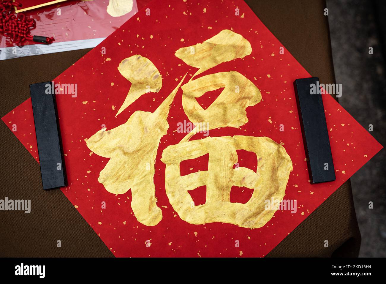 On January 24, 2022, Hong Kong, on the eve of Chinese New Year in Hong Kong, some calligraphers write lucky messages on the street. The lucky messages means 'happiness'. (Photo by Leung Man Hei/NurPhoto) Stock Photo